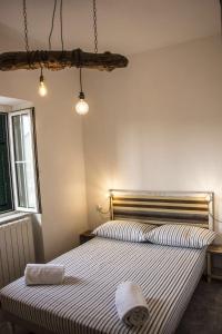 1 dormitorio con 1 cama con colcha a rayas en Apartment Sotto Il Santo en Orco Feglino