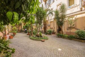 un patio con árboles y plantas en un edificio en Hotel Maryelen en Roma