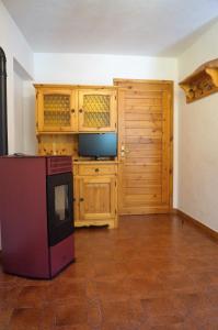 a kitchen with wooden cabinets and a tv in a room at La Maisonnette in Pré-Saint-Didier