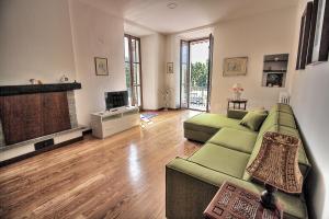 un soggiorno con divano verde e camino di Appartamento di Meri a Verbania