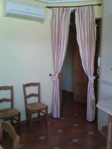a room with two chairs and a door with curtains at El Balcón de la Mancha in Tembleque