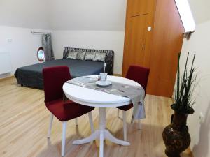 バラトンアルマーディにあるTulipán Apartmanのテーブルとベッド付きの小さな部屋