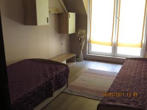 a bedroom with two beds and a large window at Bogorodi Terrace Apartment in Burgas