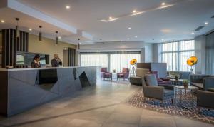 a lobby with two people standing at a counter at Maldron Hotel Pearse Street in Dublin