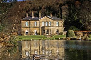 an old house with a pond in front of it at Hackness Grange Wedding Venue in Scarborough