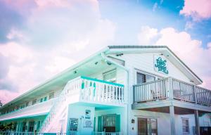 a white house with a balcony on it at The BoatHouse in Marco Island