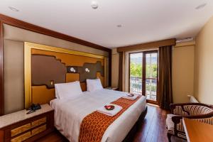una camera d'albergo con un letto grande e una finestra di Yawar Inka Hotel a Cuzco