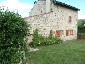 an external view of a stone house with a yard at Gite Le Fournial et ses animaux - 5 personnes in Pinet