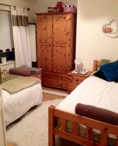 a bedroom with two beds and a wooden cabinet at Gracefield in Artane