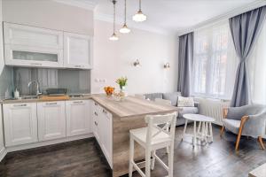 a kitchen with white cabinets and a table and chairs at Sweet 16 Studio in Ljubljana