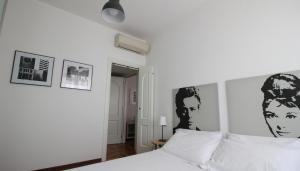 a bedroom with a white bed with black and white posters at Italianway-Lodi 78 in Milan