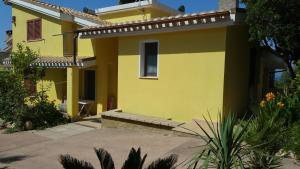 a yellow house with a driveway in front of it at Artistika Golden Apartment in Capitana