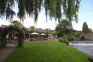 een gebouw naast een rivier met een grasveld bij Fisherman's Cot, Tiverton by Marston's Inns in Tiverton