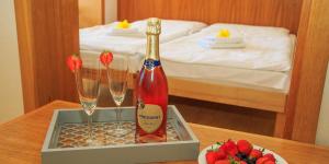 een fles champagne en twee glazen op een tafel bij Hotel Gold in Terchová