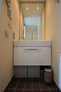 a bathroom with a large white vanity and a mirror at Duinenzicht II-Vosseslag De Haan in De Haan