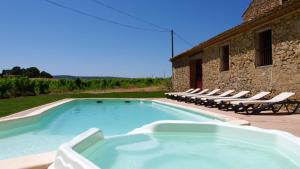 a large swimming pool with lounge chairs and a building at Chateau Le Vergel Authenac in Ginestas