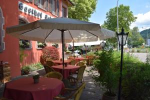 a patio with tables and chairs and an umbrella at Hotel-Restaurant Ochsen in Haslach im Kinzigtal