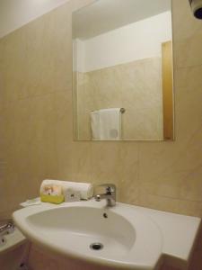 uma casa de banho com um lavatório branco e um espelho. em Hotel Kristall em San Massimo