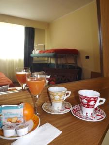 Hotel Kristall في سان ماسيمو: طاولة خشبية عليها كوبين ومشروبات