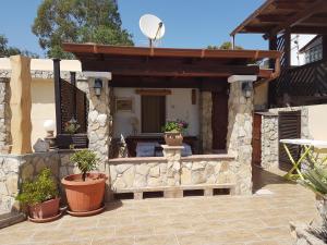 un edificio de piedra con macetas en un patio en MareSole a Capitana, en Capitana