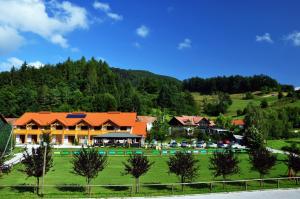 ein Haus mit einem orangenen Dach auf einem grünen Feld in der Unterkunft Natura Amon in Podčetrtek