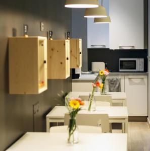 kuchnia z dwoma stołami z wazami kwiatów na nich w obiekcie B&B Lo Studio w mieście LʼAquila