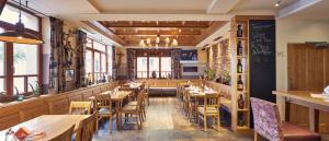 un ristorante con tavoli e sedie in legno e finestre di Hauerwirt a Sankt Peter am Wimberg