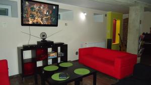 a living room with a red couch and a table at La Guitarra Hostel Gdańsk in Gdańsk
