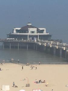 people on the beach in front of a pier at apartment Seaside in Blankenberge