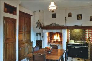 Ravenel的住宿－樂特姆斯頓若威酒店，厨房配有木桌和壁炉。