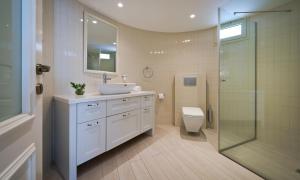 a bathroom with a sink and a toilet and a shower at Noa's Place in Eilat +12 photos