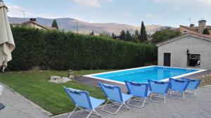 un grupo de sillas azules junto a una piscina en Casa El balcón de Iria, en Otero de Herreros