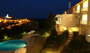 a view of a building and a swimming pool at night at Pousada de Bragança - Sao Bartolomeu in Bragança