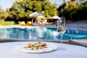 a plate of food and a glass of wine on a table at Pousada de Bragança - Sao Bartolomeu in Bragança