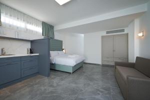a bedroom with a bed and a couch in it at Roni Suite in Eilat +3 photos