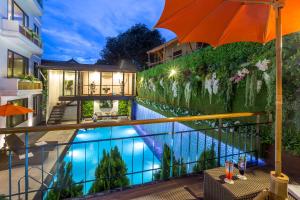 a house with a swimming pool and an umbrella at Jomkitti Boutique Hotel in Chiang Mai