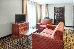 ein Hotelzimmer mit 2 Stühlen und einem TV in der Unterkunft Extended Studio Suites Hotel- Bossier City in Bossier City