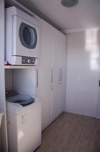 uma cozinha com uma máquina de lavar roupa e um micro-ondas em Casa Bem Vino em Bento Gonçalves