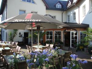 a restaurant with tables and chairs and an umbrella at Hotel Bergschlößchen in Pockau