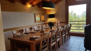 a long wooden table and chairs in a room with a window at Chalet Chaperon Rouge in Nendaz