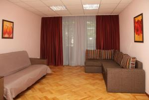 uma sala de estar com um sofá e cortinas vermelhas em Apartments on Moskovskaja em Dnipro