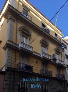 - un bâtiment jaune avec balcon et panneau dans l'établissement Ambra Noblesse, à Naples