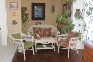 a living room with chairs and a table and a couch at Coronado Palms Coastal Cottage in Galveston