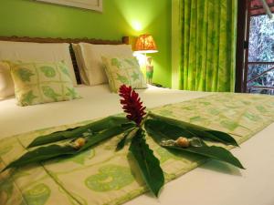 a flower arrangement in a vase on a bed at Itamambuca Eco Resort in Ubatuba