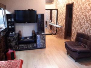een woonkamer met een bank en een flatscreen-tv bij Anasera in Tbilisi City