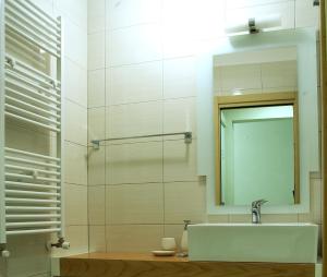 La Casa di Boz B&B في نوورو: حمام مع حوض ومرآة
