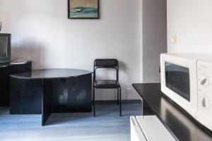 cocina con mesa, microondas y silla en Vilnius Centre Flat, en Vilna