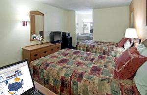 a hotel room with a bed, desk and television at Rodeway Inn in Canton