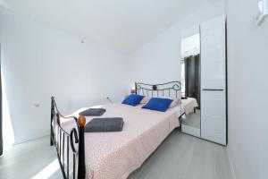 a bedroom with a bed with blue pillows and a mirror at Apartment with private pool in Sukošan +40 photos