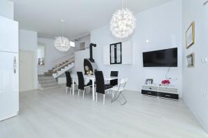 a white dining room with a table and chairs at Apartment with private pool in Sukošan